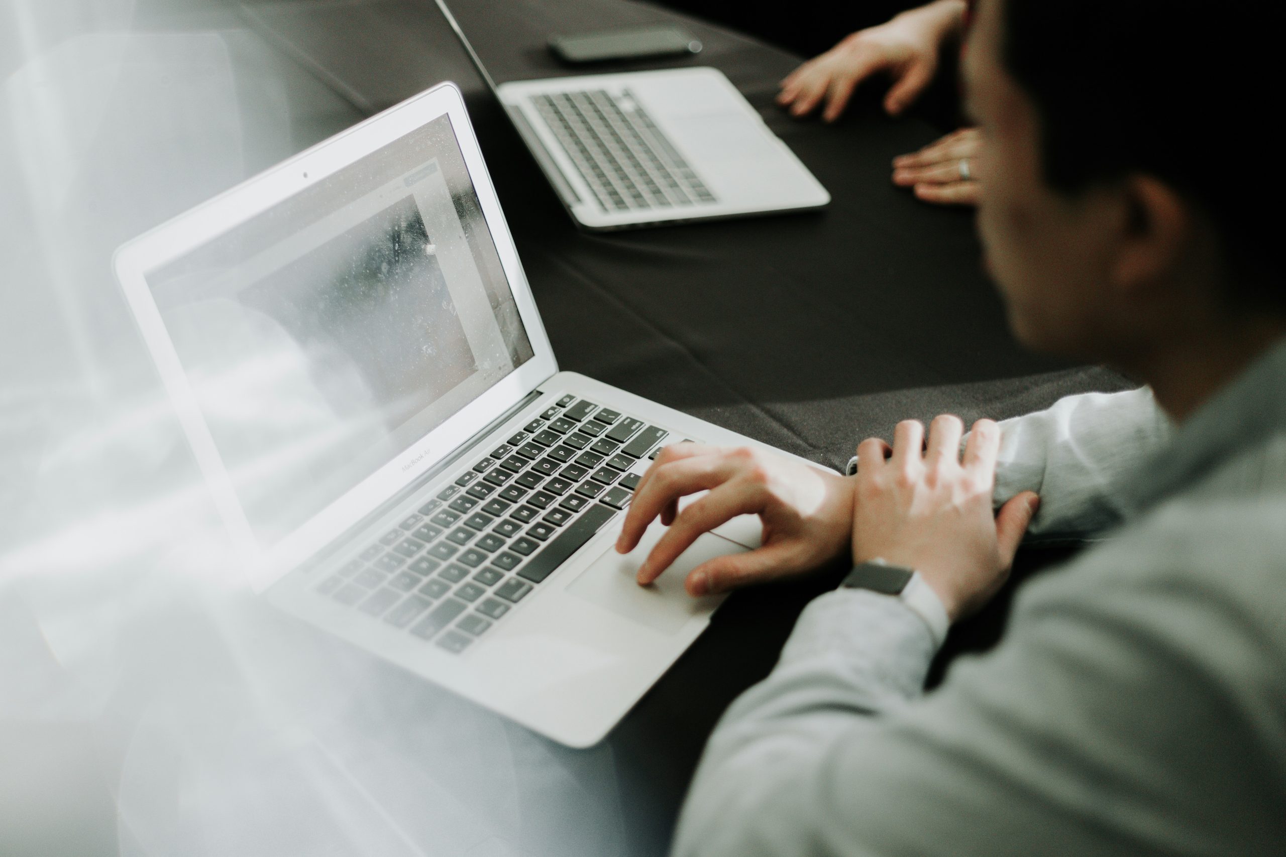 Two people reviewing information on laptops